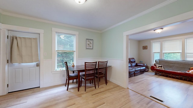 17 Wellman St, Lewiston, ME 04240 - dining area featuring light wood-style flooring, plenty of natural light, ornamental molding, and a wainscoted wall