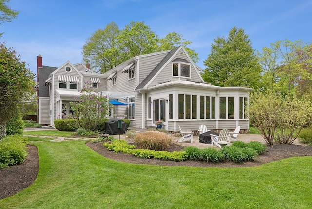 71 N St, Kennebunkport, ME 04046 - rear view of property featuring a patio, a sunroom, and a lawn