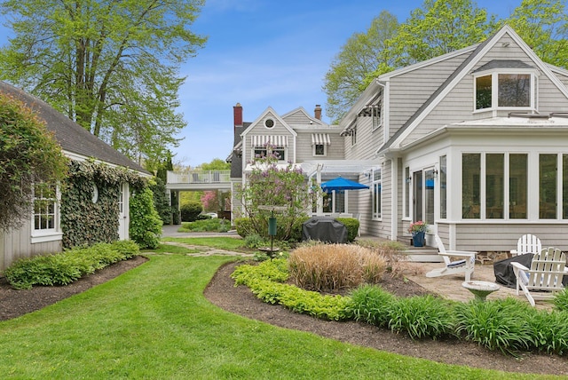71 N St, Kennebunkport, ME 04046 - rear view of property featuring a yard, a chimney, and a patio