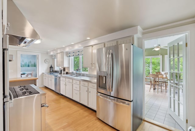 71 N St, Kennebunkport, ME 04046 - kitchen with appliances with stainless steel finishes, ceiling fan, light wood-type flooring, a sink, and white cabinets
