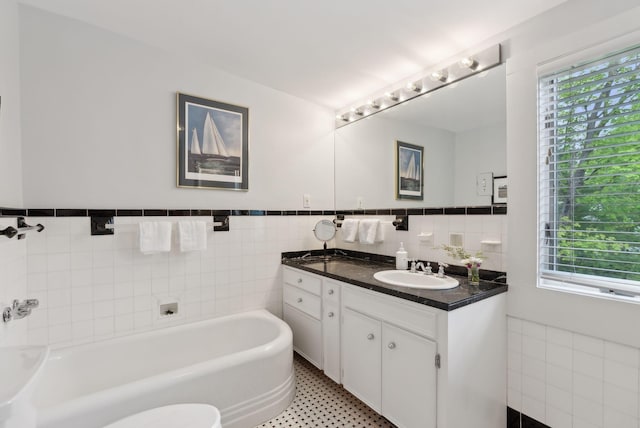 71 N St, Kennebunkport, ME 04046 - bathroom featuring a tub, healthy amount of natural light, tile walls, vanity, and wainscoting