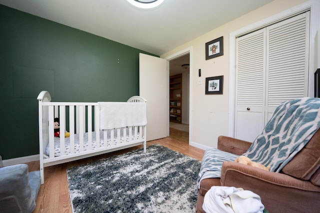 22 Meadow Rd, Hampden, ME 04444 - bedroom featuring wood finished floors, a closet, baseboards, and a crib