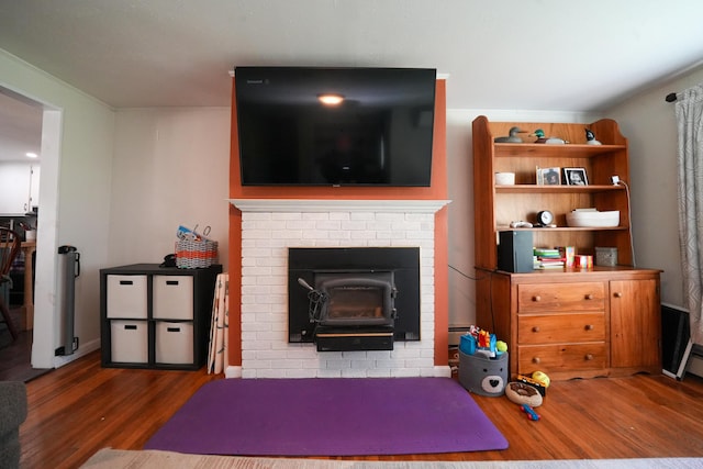 22 Meadow Rd, Hampden, ME 04444 - living room featuring wood finished floors, a wood stove, and a baseboard heating unit