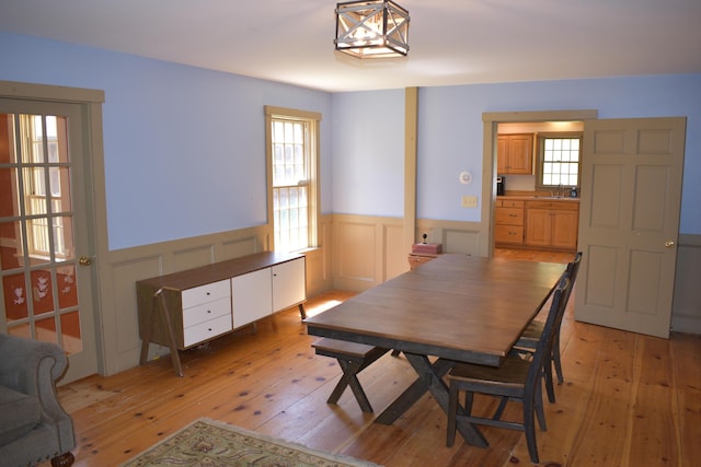 306 Campbell Rd, Leeds, ME 04263 - dining area with a wainscoted wall, light wood-style flooring, and a decorative wall
