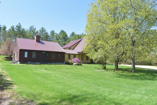 306 Campbell Rd, Leeds, ME 04263 - view of front facade featuring a front lawn, a chimney, and metal roof