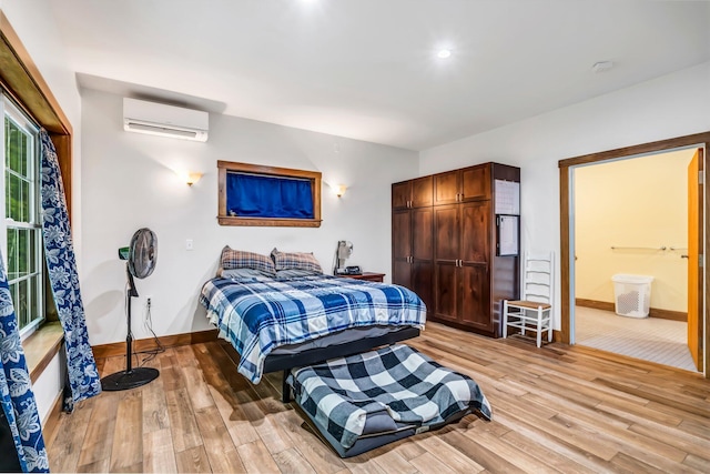 66 Mcnally Rd, Clinton, ME 04927 - bedroom with a wall mounted air conditioner, baseboards, light wood-type flooring, and ensuite bathroom