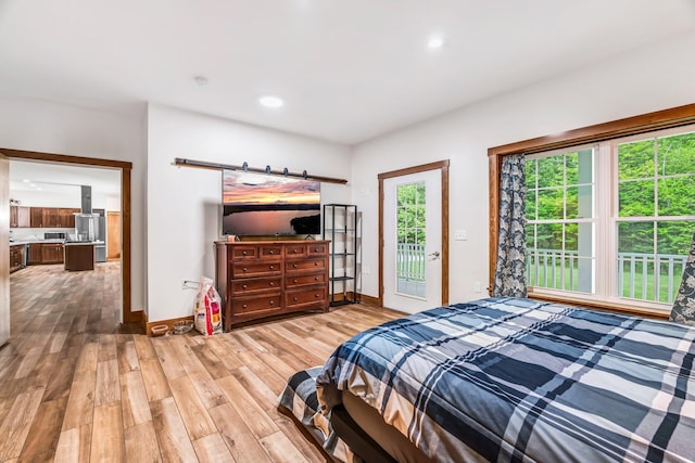 66 Mcnally Rd, Clinton, ME 04927 - bedroom with access to outside, wood finished floors, baseboards, a barn door, and recessed lighting