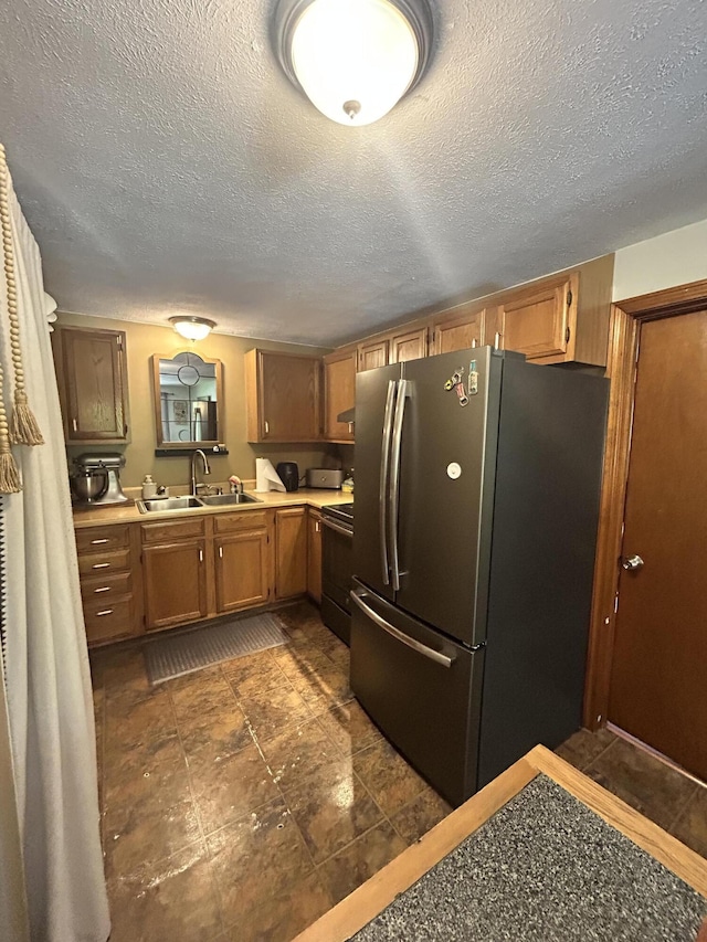 208 New Rd, Arundel, ME 04046 - kitchen with appliances with stainless steel finishes, a sink, light countertops, brown cabinets, and a textured ceiling
