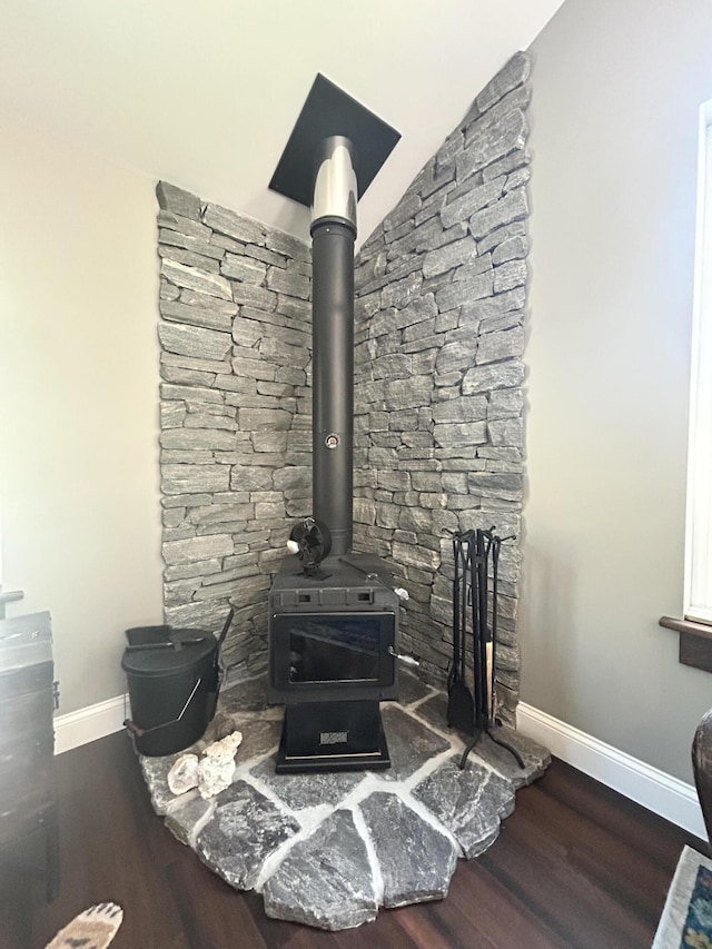 208 New Rd, Arundel, ME 04046 - detailed view of baseboards, wood finished floors, and a wood stove