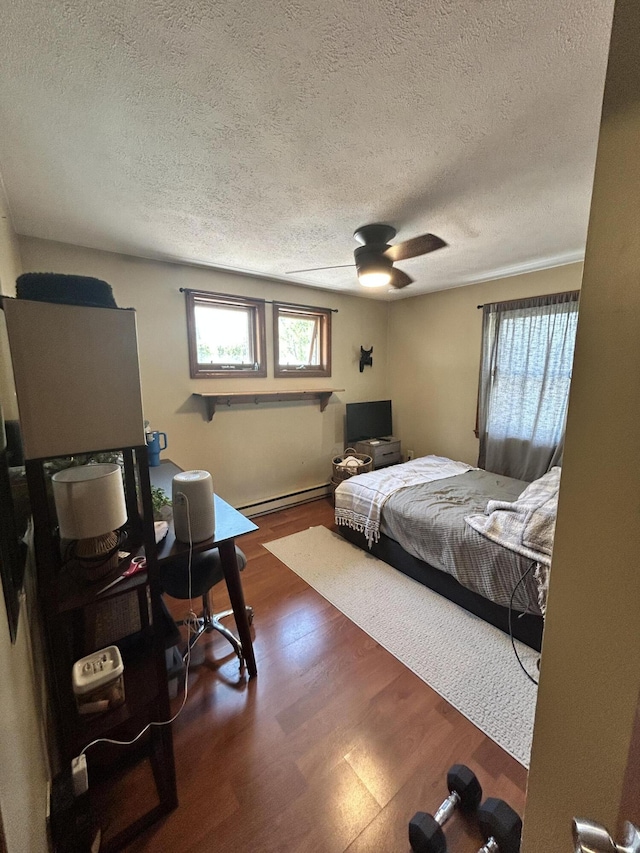 208 New Rd, Arundel, ME 04046 - bedroom with baseboard heating, a textured ceiling, wood finished floors, and ceiling fan