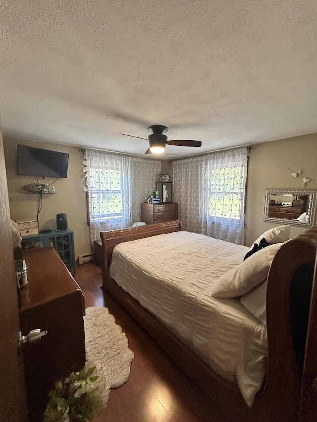 208 New Rd, Arundel, ME 04046 - bedroom featuring a textured ceiling, wood finished floors, baseboard heating, and ceiling fan