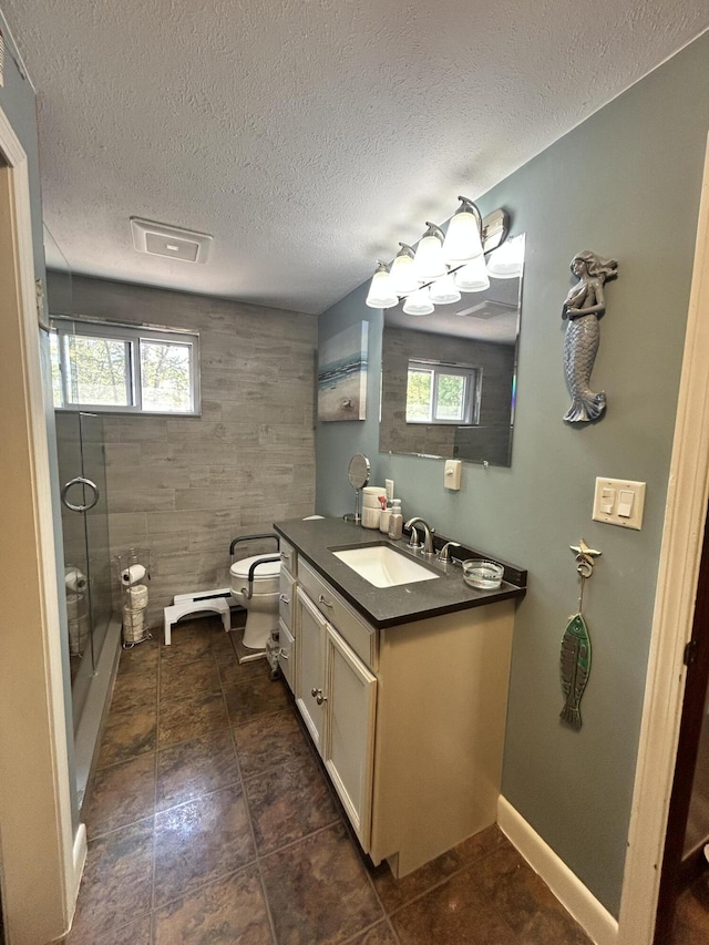208 New Rd, Arundel, ME 04046 - bathroom with toilet, vanity, a shower with shower door, a textured ceiling, and tile patterned flooring