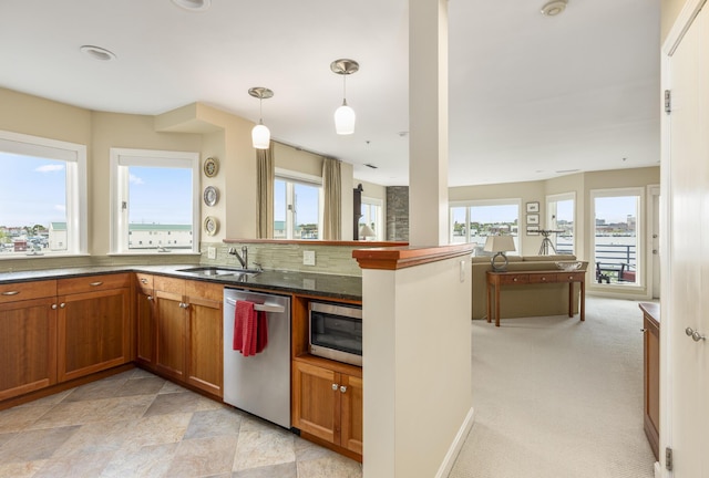 215 High St Unit 101, South Portland, ME 04106 - kitchen featuring stainless steel appliances, a sink, brown cabinetry, and hanging light fixtures