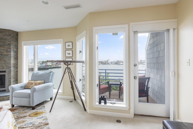 215 High St Unit 101, South Portland, ME 04106 - entryway featuring healthy amount of natural light, a stone fireplace, carpet, and a water view