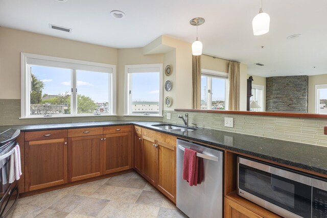215 High St Unit 101, South Portland, ME 04106 - kitchen with stainless steel appliances, a sink, dark stone countertops, and brown cabinets