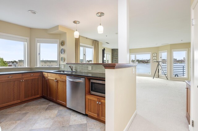 215 High St Unit 101, South Portland, ME 04106 - kitchen with appliances with stainless steel finishes, healthy amount of natural light, brown cabinets, and decorative light fixtures