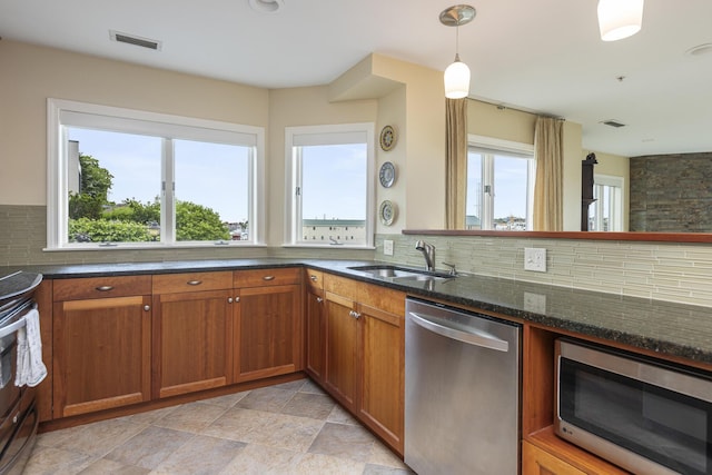 215 High St Unit 101, South Portland, ME 04106 - kitchen with stainless steel appliances, decorative backsplash, and brown cabinetry
