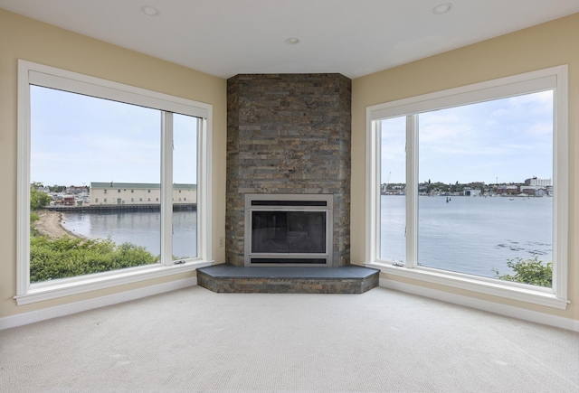 215 High St Unit 101, South Portland, ME 04106 - unfurnished living room with a water view, healthy amount of natural light, a stone fireplace, and recessed lighting