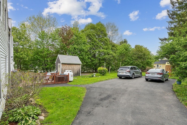 19 Cobbossee Ave, Gardiner, ME 04345 - view of car parking featuring a storage unit and view of wooded area