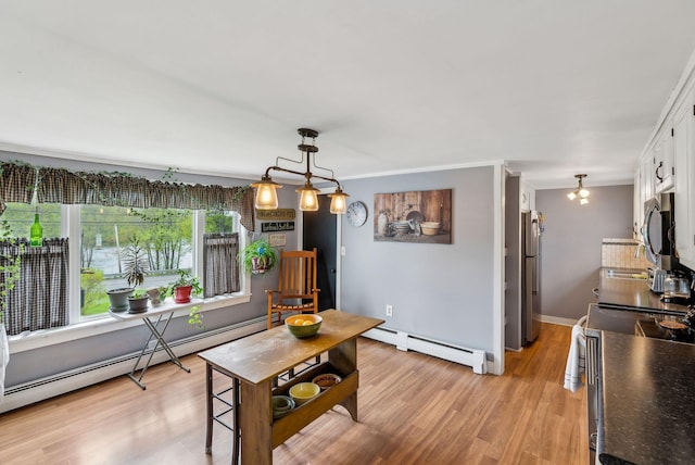 19 Cobbossee Ave, Gardiner, ME 04345 - dining area featuring a baseboard radiator, light wood-type flooring, baseboards, and crown molding