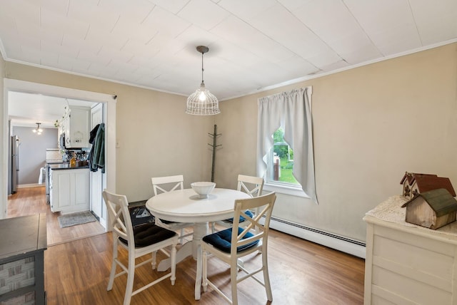 19 Cobbossee Ave, Gardiner, ME 04345 - dining room featuring ornamental molding, light wood-type flooring, and baseboard heating