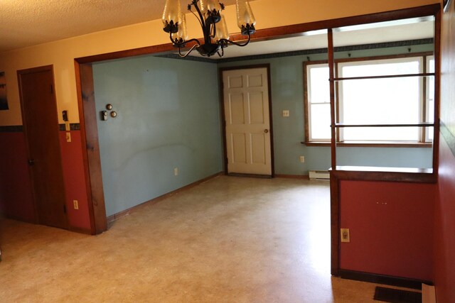 113 Pleasant St, Greenville, ME 04441 - spare room featuring a chandelier, a baseboard heating unit, and baseboards