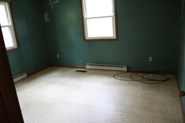 113 Pleasant St, Greenville, ME 04441 - empty room featuring a baseboard heating unit and healthy amount of natural light