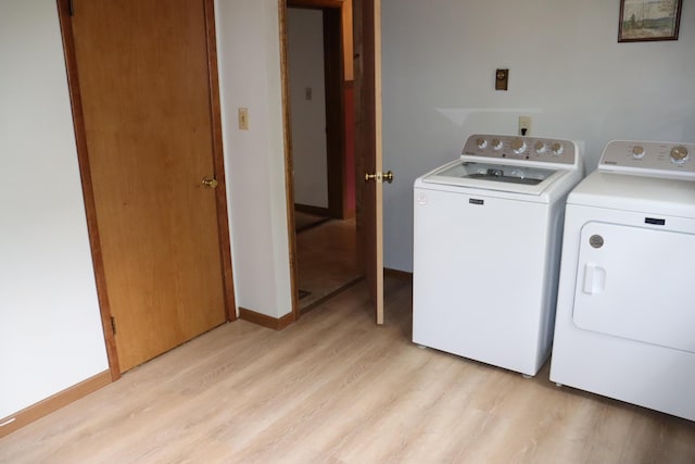 113 Pleasant St, Greenville, ME 04441 - laundry room with washer and dryer, light wood-style floors, and baseboards