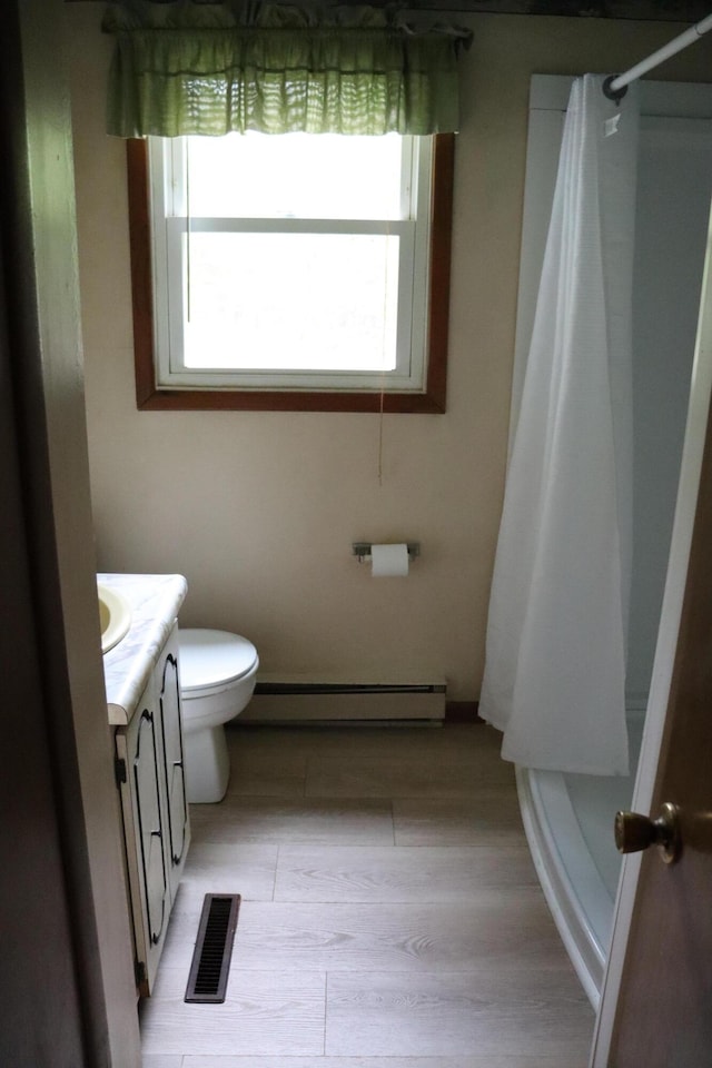 113 Pleasant St, Greenville, ME 04441 - full bath with baseboard heating, vanity, curtained shower, and toilet