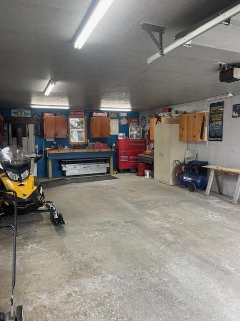 145 12th Ave, Madawaska, ME 04756 - garage with a workshop area and a garage door opener