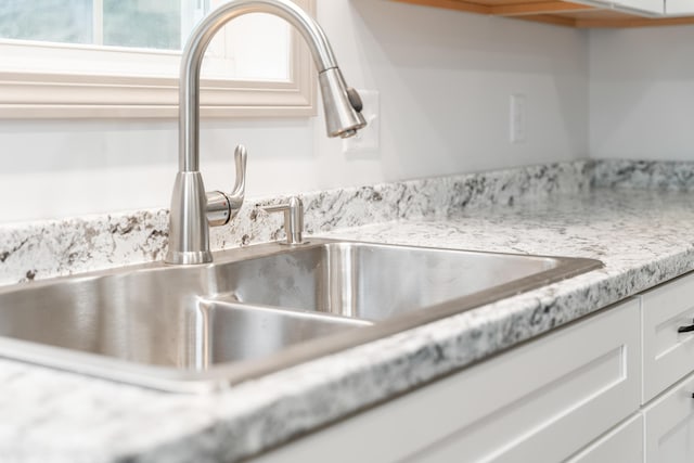 23 Bray Cir, Passadumkeag, ME 04475 - kitchen view of a sink, light countertops, and white cabinetry