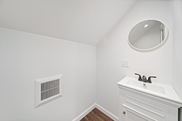 23 Bray Cir, Passadumkeag, ME 04475 - bathroom with wood finished floors, vanity, baseboards, and vaulted ceiling