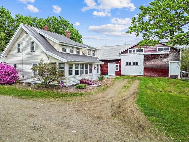 753 Ridge Rd, Windsor, ME 04363 - view of front of home featuring a chimney, driveway, metal roof, and a front yard