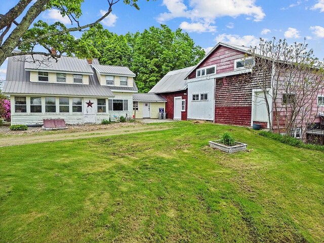753 Ridge Rd, Windsor, ME 04363 - rear view of property featuring a lawn, metal roof, and a chimney