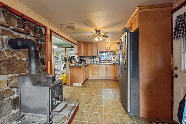 753 Ridge Rd, Windsor, ME 04363 - kitchen with stainless steel appliances, a ceiling fan, a wood stove, a sink, and light tile patterned flooring
