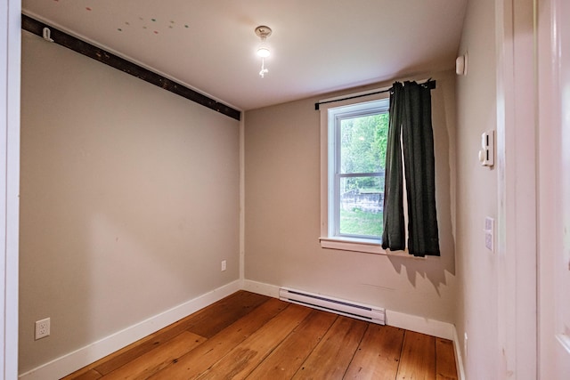76 Old W Bethel Road, Albany Twp, ME 04217 - spare room with a baseboard heating unit, hardwood / wood-style flooring, and baseboards