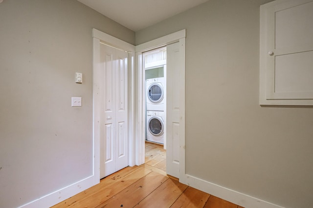 76 Old W Bethel Road, Albany Twp, ME 04217 - laundry room featuring stacked washer and clothes dryer, light wood-style floors, and baseboards