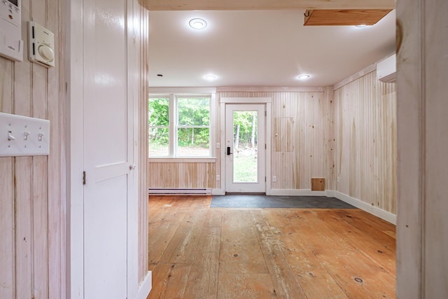 76 Old W Bethel Road, Albany Twp, ME 04217 - empty room with wood-type flooring, baseboard heating, wood walls, and baseboards
