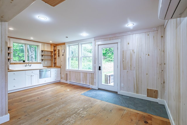 76 Old W Bethel Road, Albany Twp, ME 04217 - kitchen with light wood-style floors, a baseboard heating unit, a wall mounted AC, dishwashing machine, and healthy amount of natural light