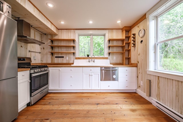 76 Old W Bethel Road, Albany Twp, ME 04217 - kitchen with stainless steel appliances, a baseboard heating unit, open shelves, light wood-style flooring, and wood walls