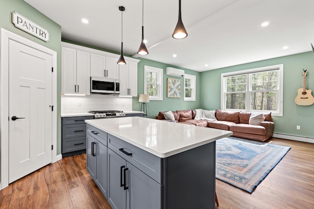 64 Autumn Rdg, Sabattus, ME 04280 - kitchen with gray cabinets, a wall mounted air conditioner, wood finished floors, light countertops, and baseboard heating