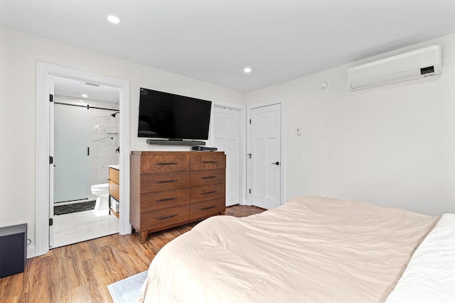 64 Autumn Rdg, Sabattus, ME 04280 - bedroom with an AC wall unit, a barn door, light wood-style floors, recessed lighting, and ensuite bathroom