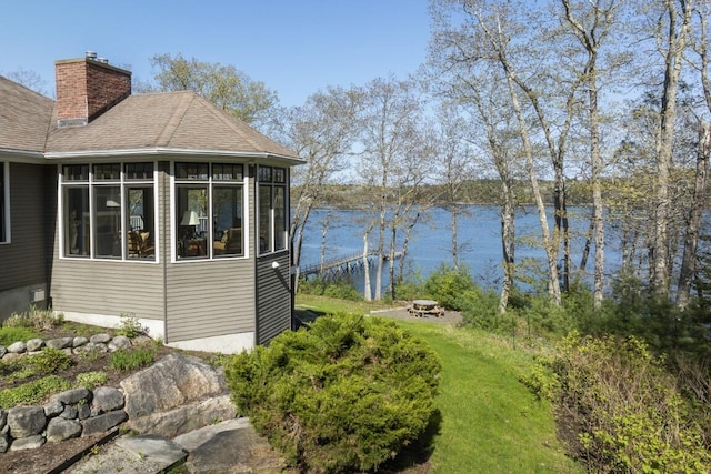 50 Higbee Ln, Boothbay, ME 04571 - view of home's exterior with a chimney, a water view, a sunroom, and a shingled roof