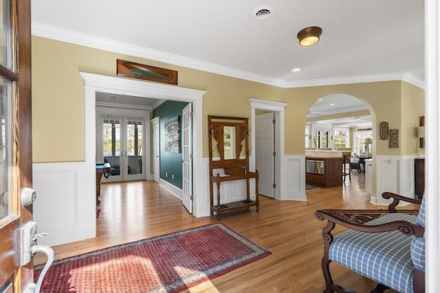 50 Higbee Ln, Boothbay, ME 04571 - foyer featuring french doors, crown molding, arched walkways, wood finished floors, and wainscoting
