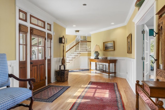 50 Higbee Ln, Boothbay, ME 04571 - entryway with wood finished floors, stairway, a wainscoted wall, crown molding, and a decorative wall