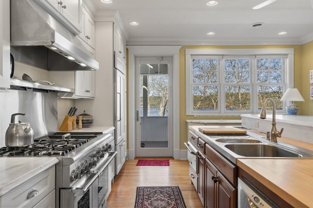 50 Higbee Ln, Boothbay, ME 04571 - kitchen with under cabinet range hood, range with two ovens, a sink, light countertops, and crown molding