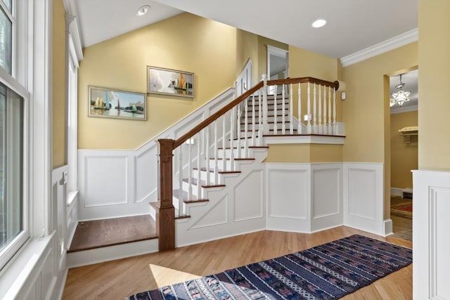 50 Higbee Ln, Boothbay, ME 04571 - staircase featuring wood finished floors, a decorative wall, wainscoting, crown molding, and a chandelier