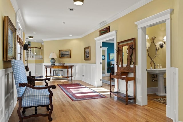 50 Higbee Ln, Boothbay, ME 04571 - living area featuring wood finished floors, a wainscoted wall, and ornamental molding