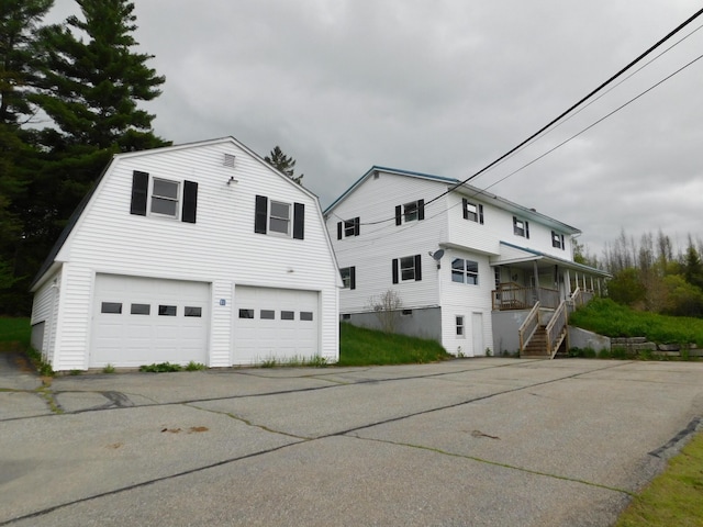 81 S Main St, Athens, ME 04912 - view of property exterior featuring a gambrel roof, a porch, stairs, and a garage