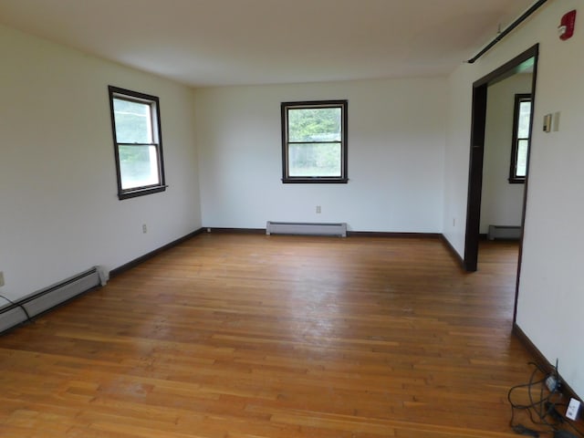 81 S Main St, Athens, ME 04912 - empty room with baseboard heating, healthy amount of natural light, a baseboard radiator, and light wood-style floors